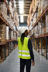 Professional in safety gear scanning packages in logistics center