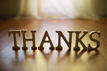Thanks Lettering Decoration on Wooden Floor with Soft Natural Light in Background