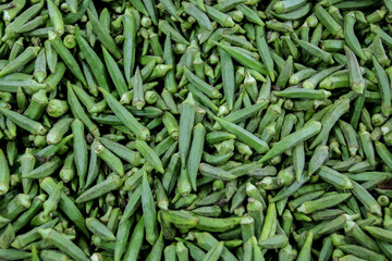 An assortment of fresh okras or ladyfingers in an Asian supermarket, fresh ladyfingers at shop closeup view, Green Lady fingers, vegetable photo, ladyfingers picture, 
