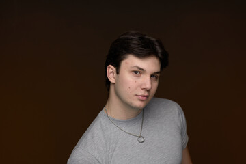 A Young Man in a Hoodie Poses Confidently in a Studio Setting With Soft Lighting, Capturing a Moment of Youthful Energy and Expression