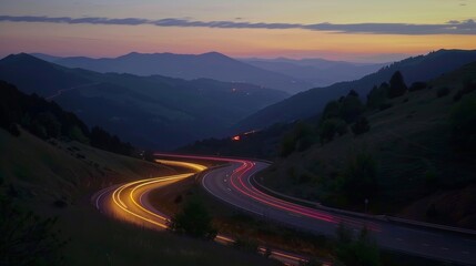 The striking contrast between the stillness of the mountains and the lively light trails of cars on a winding road.