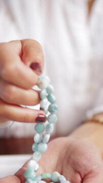 Make Bracelets From Natural Stones. Jewelry designer examining string of amazonite beads