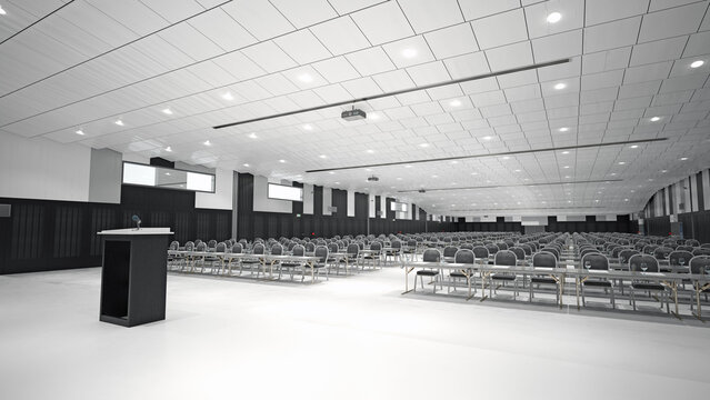 A spacious conference hall with rows of chairs and a podium