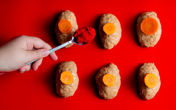 Traditional Jewish Passover food gefilte fish with carrots, horseradish, red background