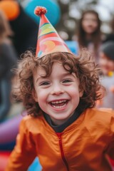 Happy Little Boy in a Party Hat Jumping with Friends