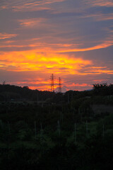 Obraz premium A dramatic sunset sky with colourful glowing clouds and a silhouetted landscape below