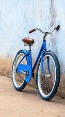 Fototapeta premium A vintage blue bicycle with a leather seat leaning against an old city wall, embodying timeless adventure and urban charm