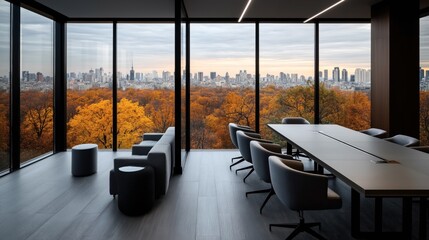 Fototapeta premium Modern office interior with large windows overlooking an autumn cityscape featuring colorful trees and a skyline of buildings.