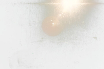 Abstract transparent  image of a bright light shining through a scratched and dirty window.