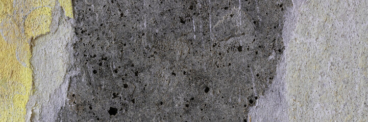 Torn old faded paper wallpaper with a retro pattern. Tattered scraps of paper on a concrete wall. Vintage texture for background and design. Closeup view with copy space.