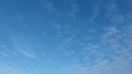 Obraz premium a clear blue sky with a few scattered, wispy clouds. The clouds are thin and spread out, giving the sky a serene and open appearance.