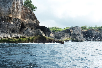 Fototapeta premium Landscape of rocky cliff at the sea and destination travel seascape on summer ocean in Bali island at Indonesia