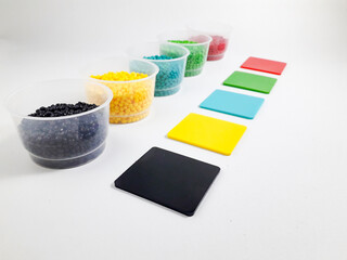 Various colors of masterbatch granules in a cup equipped with color chips as examples of the...