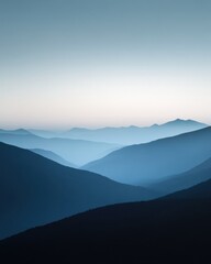 Serene view of layered blue mountains under a calm sky.
