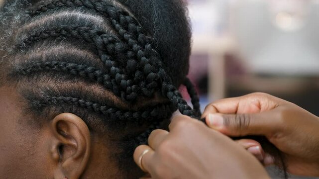 Hairdresser making crochet braids to a client in an afro hair salon