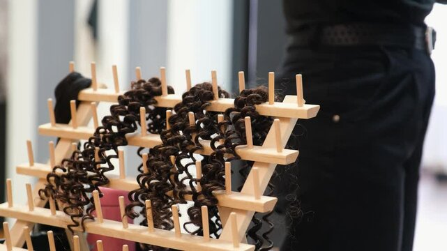 Unrecognizable hairdresser preparing the hair extension, artificial hair, to make crochet braids in an afro hair salon