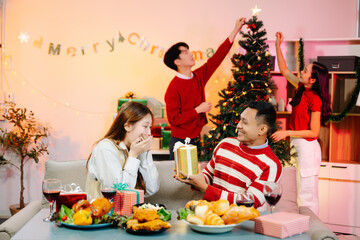 Holiday spirit with Asian friends exchanging gifts, sharing laughs, and enjoying a festive Christmas dinner