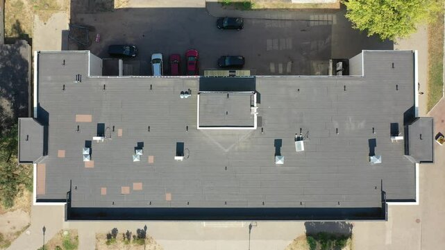 Vertical aerial view from a drone on the roof of an office building, office, shopping center. Drone flying over the city.