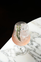 Mediterranean Spritz Cocktail with sweet vermouth, wine, thyme prosecco and ice cubes