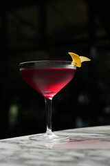 Cosmopolitan Martini cocktail glass on a marble table background with copy space, close-up