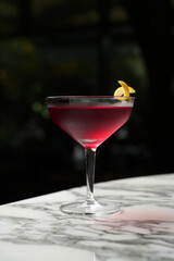 Cosmopolitan Martini cocktail glass on a marble table background with copy space, close-up