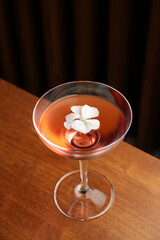 Cocktail with peach liqueur, wine and vanilla flower petals.