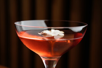 Cocktail with peach liqueur, wine and vanilla flower petals.