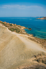 Geological formation in Qarraba Bay, Mgarr, Malta island. Scenic viewpoint over Riviera Bay, Ghajn Tuffieha Bay and Qarraba Beach with red sand.