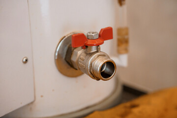 Detailed Close-Up of a Brass Water Valve with Red Handles and Connection Fittings