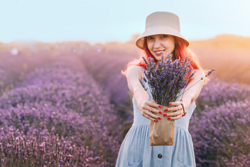 A young woman embraces nature, holding a lavender bouquet in a beautiful floral field, radiating relaxation.