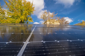 Duży panel słoneczny do generowania energii elektrycznej, odbicie nieba w gładkiej powierzchni. Piękne błękitne niebo z drobnymi białymi chmurami, odbite w dużym gładkim panelu słonecznym.  © Grzegorz