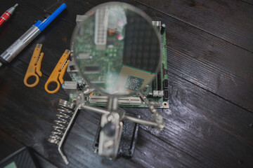 Asian male computer repairman is checking and fixing hardware problems on computers and replacing...