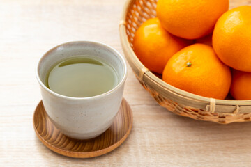 テーブルに置かれたミカンと緑茶