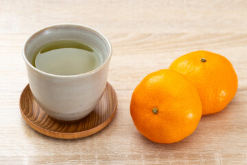 テーブルに置かれたミカンと緑茶
