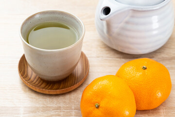テーブルに置かれたミカンと緑茶