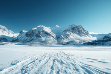 Snow-covered mountains rise majestically under a clear blue sky in a serene winter landscape, showcasing the beauty of nature