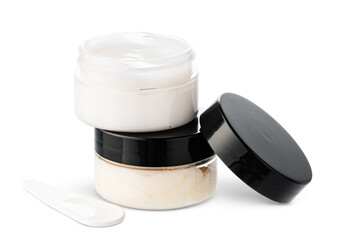 Open cosmetic jars showcasing different creams set against a clean white background