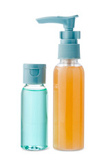 Various bottles with colored liquids and pumps arranged on white background