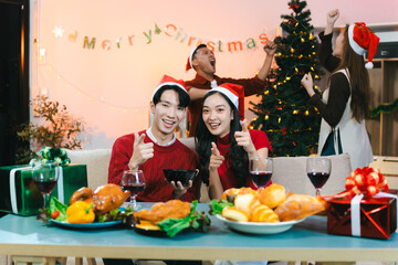 Dinner and group of people celebrating together at Merry Christmas & Happy New Year. Friends are happy and celebrating with food, wine and friendship of love and gift exchange at the event.
