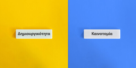 Creativity versus Innovation Words and Concept Image. Text on Block Letter Tiles on Yellow and Blue...