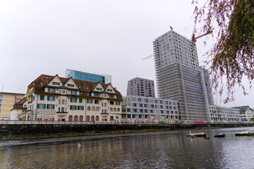 Fototapeta premium Scenic view of Limmat River with skyline at industrial district of Swiss City of Zürich on a foggy autumn day. Photo taken November 2nd, 2024, Zurich, Switzerland.