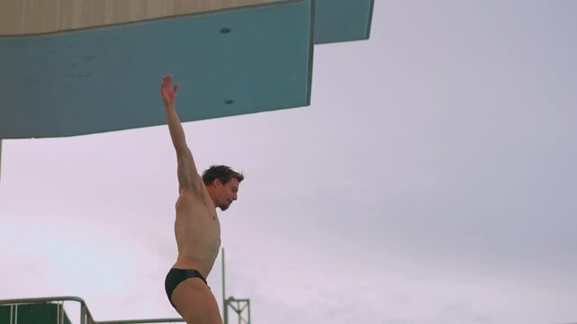 A professional athlete perfects his spring dive during training. The video showcases his dedication, technique, and athletic prowess as he practices each dive with precision and focus. Slowmotion
