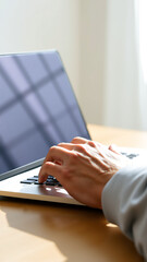 Fototapeta premium hand typing on a laptop with a window reflection