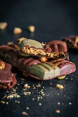 Dubai chocolate with pistachio cream, kadayif and pistachios on dark background