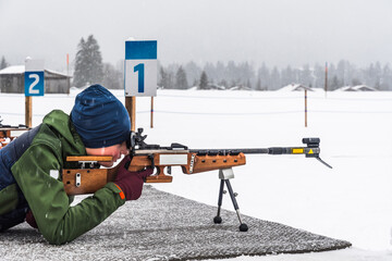 Boy doing target practice with a laser gun for biathlon training in winter