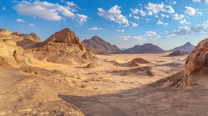 Naklejka premium A panoramic view of a vast desert landscape with mountains and a clear blue sky.