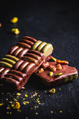 Dubai chocolate with pistachio cream, kadayif and pistachios on dark background