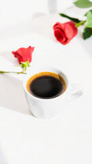 Obraz premium white mug coffee with red roses the background