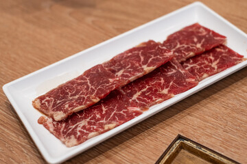 Delicious fresh raw juicy kobe wagyu marbled beef pork meat slice on plate ingredient for food sukiyaki yakiniku steak healthy meal Japanese traditional dining culture restaurant high protein bar-b-q