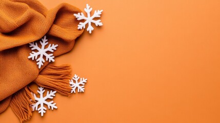 Orange Knit Scarf and White Snowflakes on Orange Background for Winter Holidays